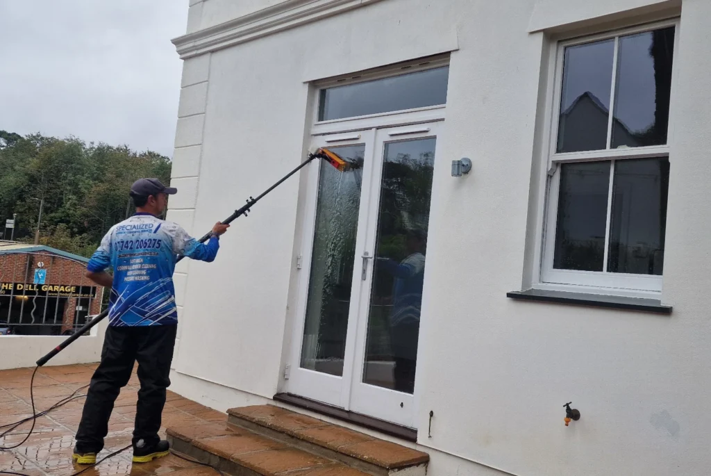 Window cleaner cleaning glass doors on house.
